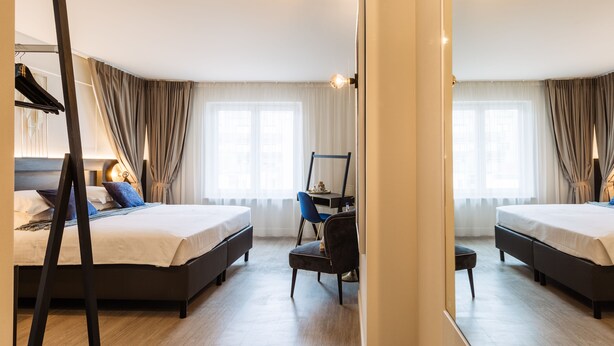 Une chambre d’hôtel avec deux lits, un bureau et une chaise.