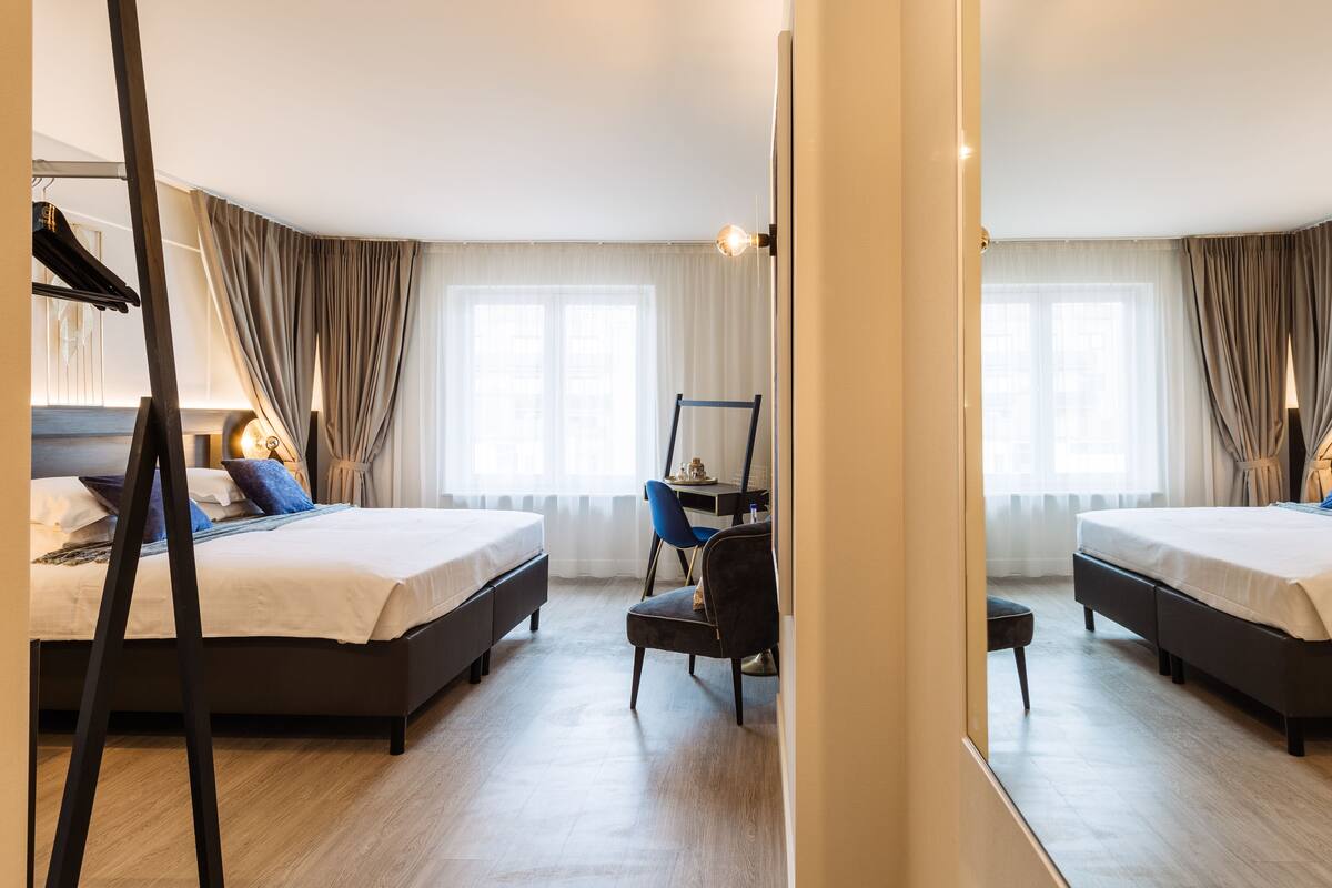 Una habitación de hotel con dos camas, un escritorio y una silla.