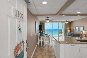 Una habitación de hotel con balcón, comedor y cocina.