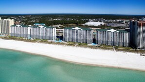 Ein Strandhotel mit mehreren Hochhäusern, einem Sandstrand und freiem Blick auf den Ozean.