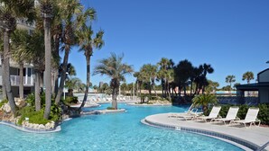 Ein Swimmingpool mit Liegestühlen und Palmen.