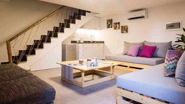 A modern apartment with a staircase, a kitchen, a sofa, and a coffee table. - Old Town Guest Houses (Batroun)