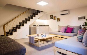 A modern apartment with a staircase, a kitchen, a sofa, and a coffee table. - Old Town Guest Houses (Batroun)