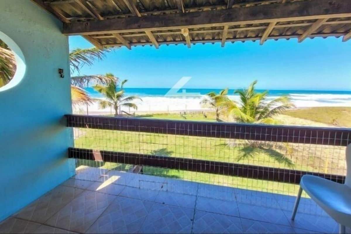 A balcony with a view of the beach and ocean.