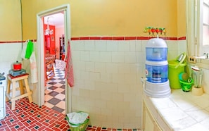 A kitchen with a water dispenser, a sink, and a tiled floor. - Casa Mildred (Havana)