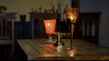 Una mesa de madera con una vela y un vaso encima.