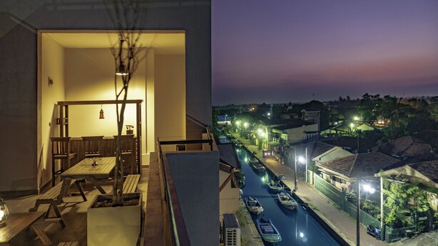 A dining area with wooden furniture and a hanging light fixture. - Hive 68 - Hotel and Resorts Negombo (Negombo)