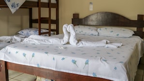 Una cama con un edredón floral y una toalla doblada en forma de corazón.