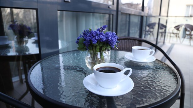 A glass table with a cup of coffee and a vase of flowers. - -30% off  Natalité Houzz Tbilisi (Tbilisi)