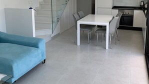 Un espacio habitable moderno con escalera, comedor y cocina.