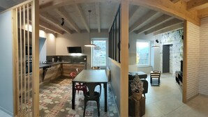 A spacious kitchen with a dining area, a staircase, and a living room with a fireplace. - Comfortable house and neat decoration, view of the Sioule valley. WiFi. (Chateauneuf-les-bains)
