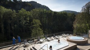 A deck with hot tubs and lounge chairs overlooking a forested area. - Comfortable house and neat decoration, view of the Sioule valley. WiFi. (Chateauneuf-les-bains)