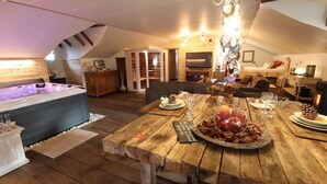 A cozy dining area with a wooden table set for a meal, a hot tub, and a TV in the background. - house with private pool, jacuzzi, sauna, hammam for 4 adults, 2 children (Theux)