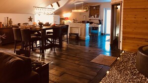 A cozy kitchen with a dining area, wooden flooring, and a modern chandelier. - house with private pool, jacuzzi, sauna, hammam for 4 adults, 2 children (Theux)