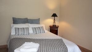 A neatly made bed with patterned pillows, a bedside lamp, and a folded towel on the bed. - Family farmhouse in Provence on a vineyard with authentic swimming pool (Mondragon)