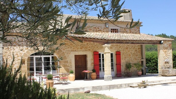 A stone building with a tiled roof, a covered patio with outdoor furniture, and a small garden area. - Family farmhouse in Provence on a vineyard with authentic swimming pool (Mondragon)