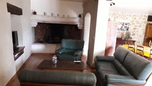 A living room with a fireplace, a television, and a dining area. - Family farmhouse in Provence on a vineyard with authentic swimming pool (Mondragon)