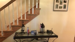 A glass-top table with a telephone, a lantern, a can of shaving cream, and a box of shaving gel. - Luxury Lakefront Living in Lake Sebago Area (Bridgton)