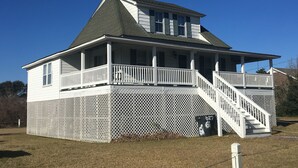 A two-story house with a porch and a staircase leading to the upper level.