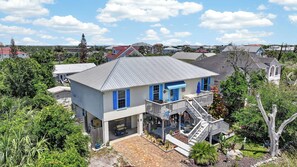 A two-story house with a covered porch and a garage. - Pet Friendly Apartment- Walk To The Beach (Palm Coast)
