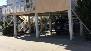 Un immeuble de deux étages doté d’un balcon et d’un espace de stationnement couvert.