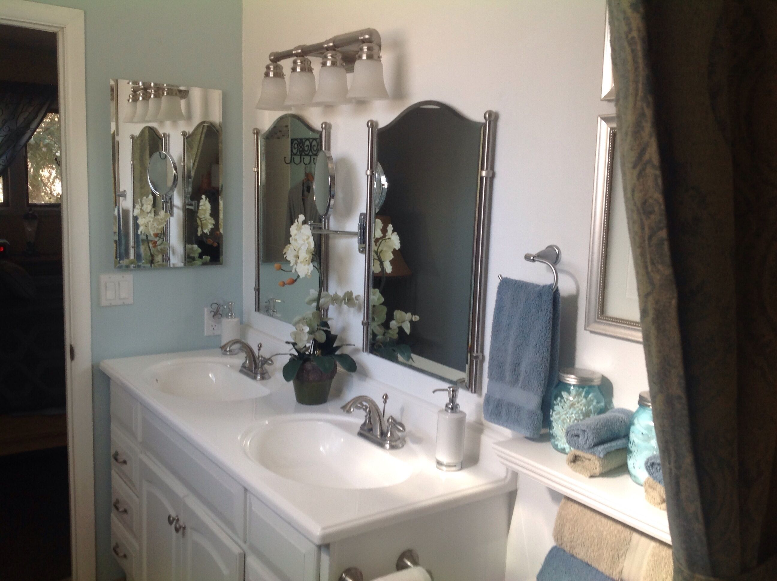 A bathroom with two sinks, a mirror, and a towel rack.