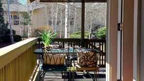 A covered outdoor patio with a wooden deck, outdoor furniture, and a dog. - Amazing 5 Star Home, Amenities Galore, AC, no pet fee, 7 miles to NAU (Flagstaff)
