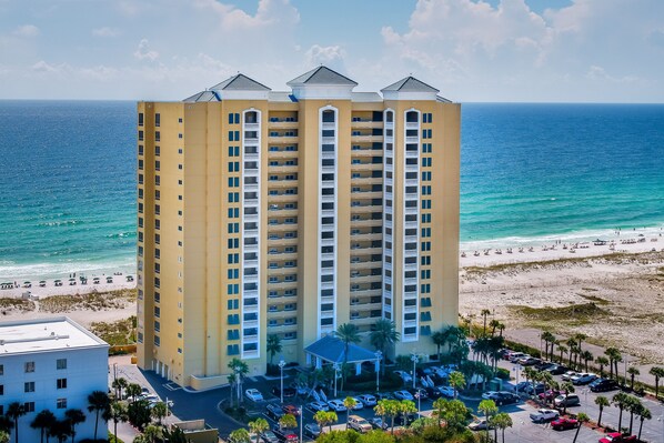 Un grand hôtel doté de nombreux balcons donnant sur une plage et l’océan.