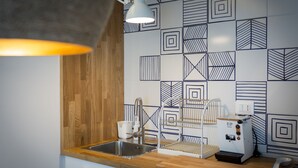 A kitchen with a wooden countertop, a stainless steel sink, a coffee machine, and a patterned backsplash. - Salsedine Sea View (Salerno)