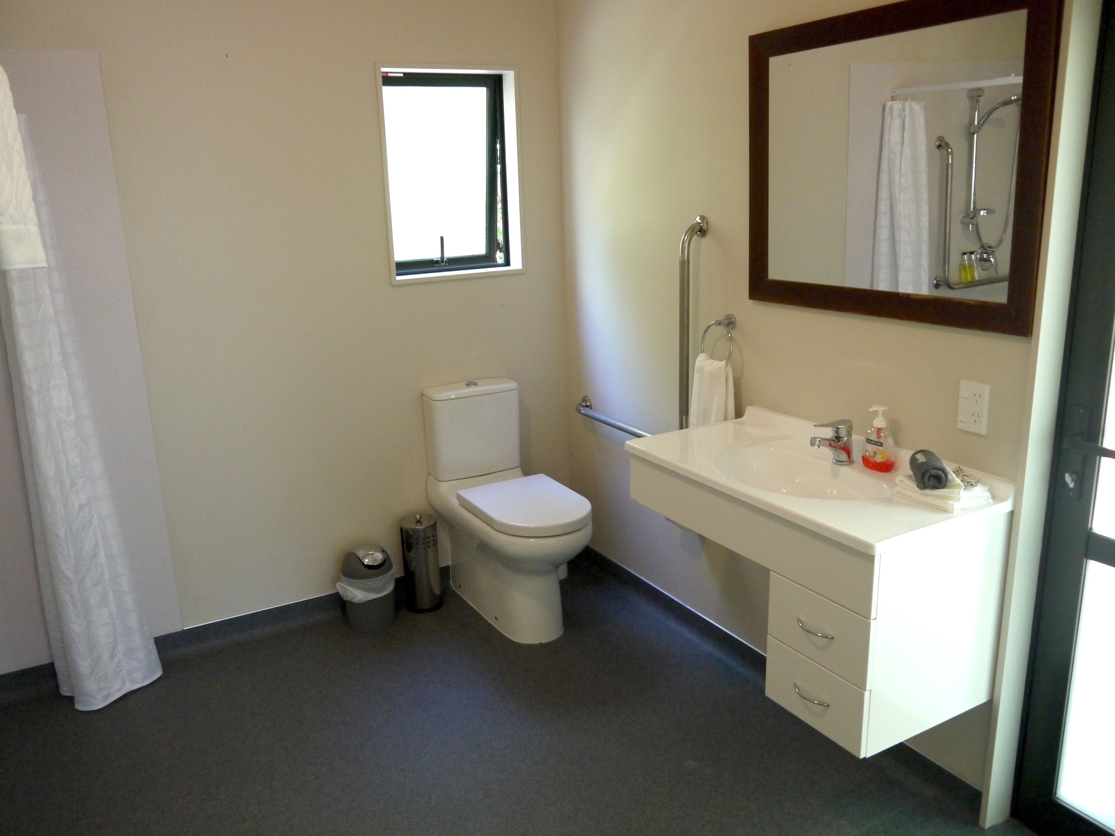 A bathroom with a toilet, sink, and shower.