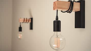 A modern light fixture with a clear glass bulb and a wooden base.