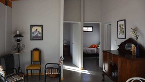A spacious living area with a high ceiling, a dining table, chairs, a sofa, and a fireplace. - El Fresno (Mendoza)