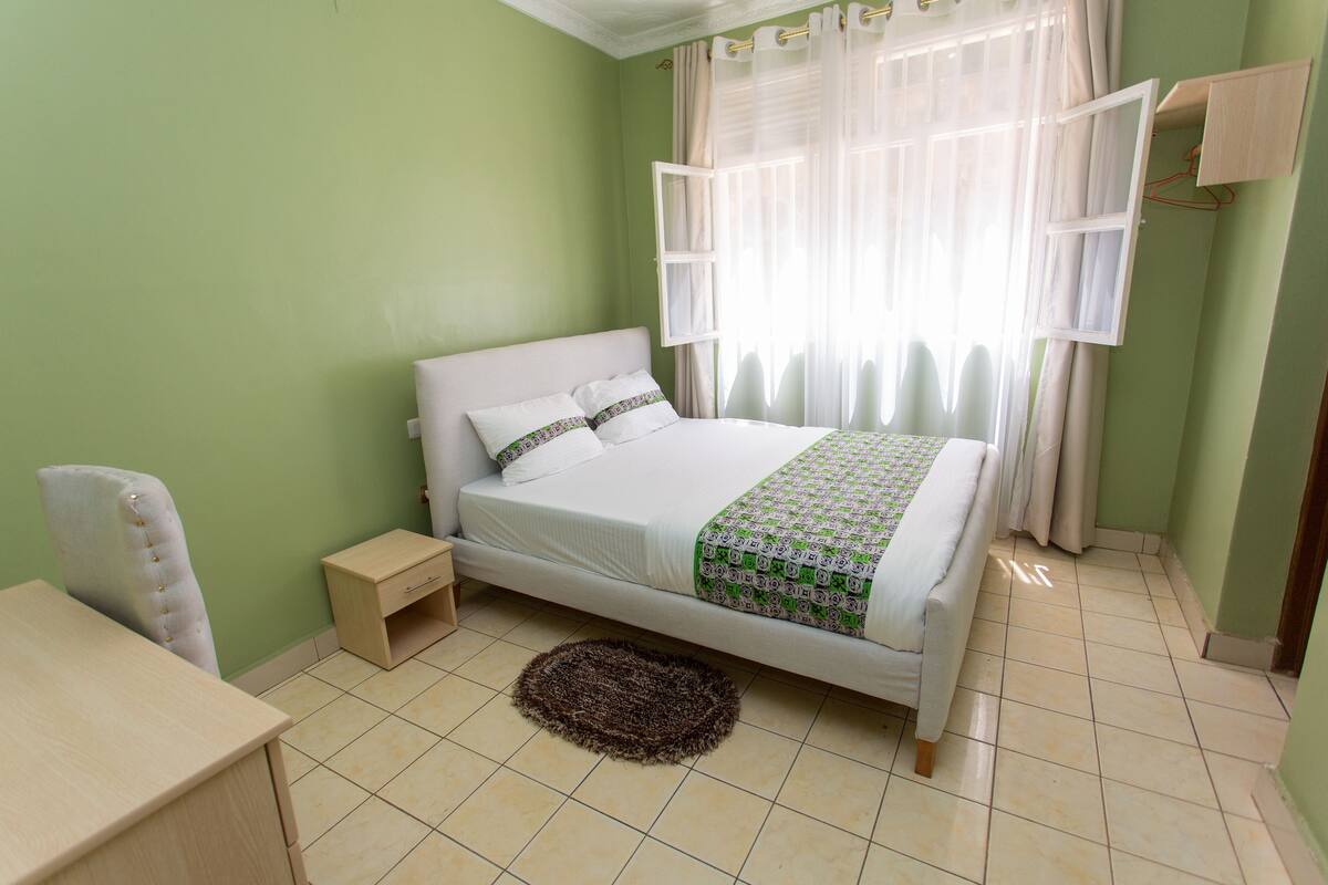 A bedroom with a bed, a desk, and a chair.