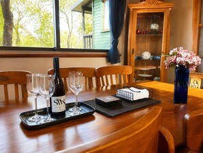 Una mesa puesta con copas de vino, una botella y un florero con flores.