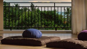 Een balkon met uitzicht op palmbomen en de oceaan.