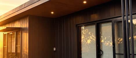 A modern building with a flat roof, large sliding glass doors, and a geometric patterned tile floor.