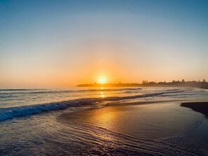 A beach at sunset with waves gently lapping the shore. - Culburra Retreat - Newly Renovated, Pet Friendly, 4 Min Walk to the Beach (Culburra Beach)