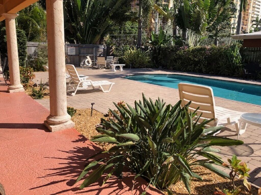 A pool area with lounge chairs and a pergola structure.