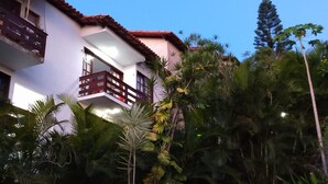 A two-story building with a red balcony and a white facade. - Apartment in Cabo Frio, completely renovated, new furniture, bright, spacious, airy, quiet. (Cabo Frio)