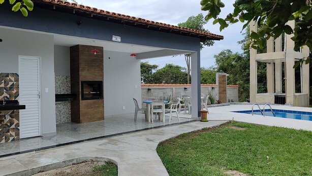 A covered outdoor area with a pool, a barbecue, and a seating area. - Apartment in Cabo Frio, completely renovated, new furniture, bright, spacious, airy, quiet. (Cabo Frio)