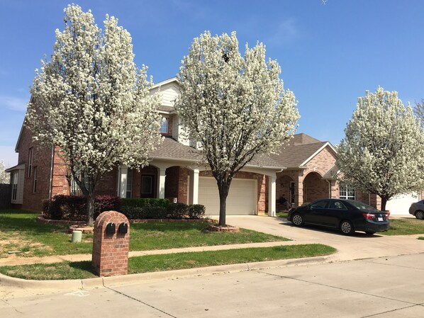 Stunning home with a brick facade, symmetrical design, and a central entrance flanked by windows.
