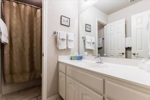 Enjoy a comfortable stay in this well-appointed bathroom with a large mirror, sink, and shower area.