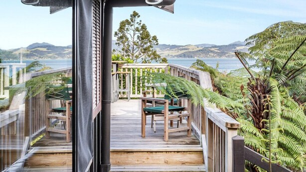 A wooden deck with a view of the ocean and hills. - Coromandel Cottage  - Romantic Rustic - Sea views (Coromandel Township)