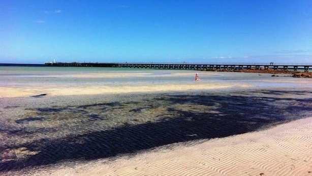 A beach with clear water, a sandy shore, and a pier extending into the water. - Moontana @ Moonta Bay (Moonta Bay)