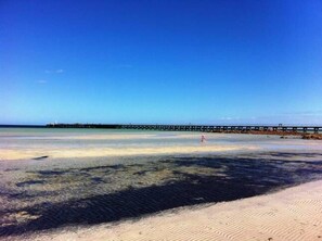 A beach with clear water, a sandy shore, and a pier extending into the water. - Moontana @ Moonta Bay (Moonta Bay)