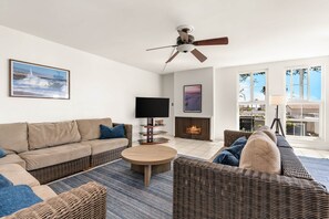 A modern living room with a sofa, coffee table, and a fireplace. - Oceanview Condo - 2nd floor - "Alexander" (Newport Beach)