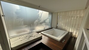 A modern bathroom with a wooden floor, a large window with frosted glass, a bathtub, and a bench. - Spend your holidays at a club. (Nações)