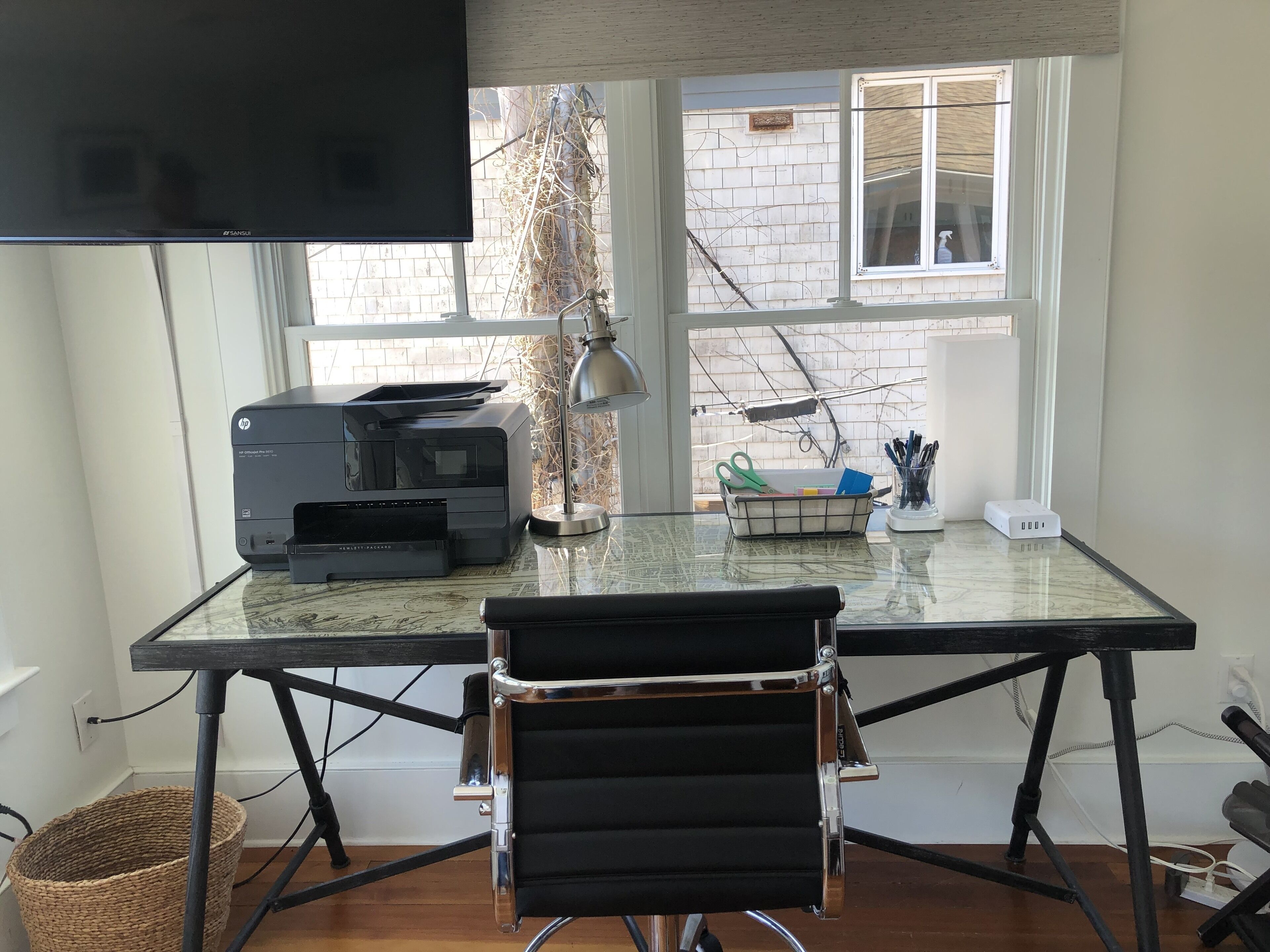A workspace with a printer, lamp, and desk chair.
