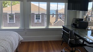 A bedroom with a large window, a bed, a desk with a computer, and a chair. - Charming 2br/2ba - steps 2 beach and all Ptown has to offer!  (Provincetown)
