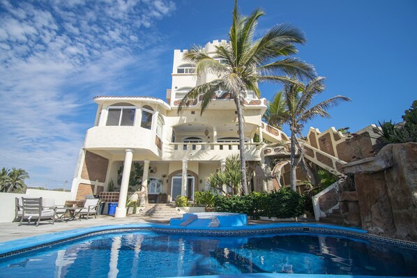 A large, multi-story building with a pool in the foreground.